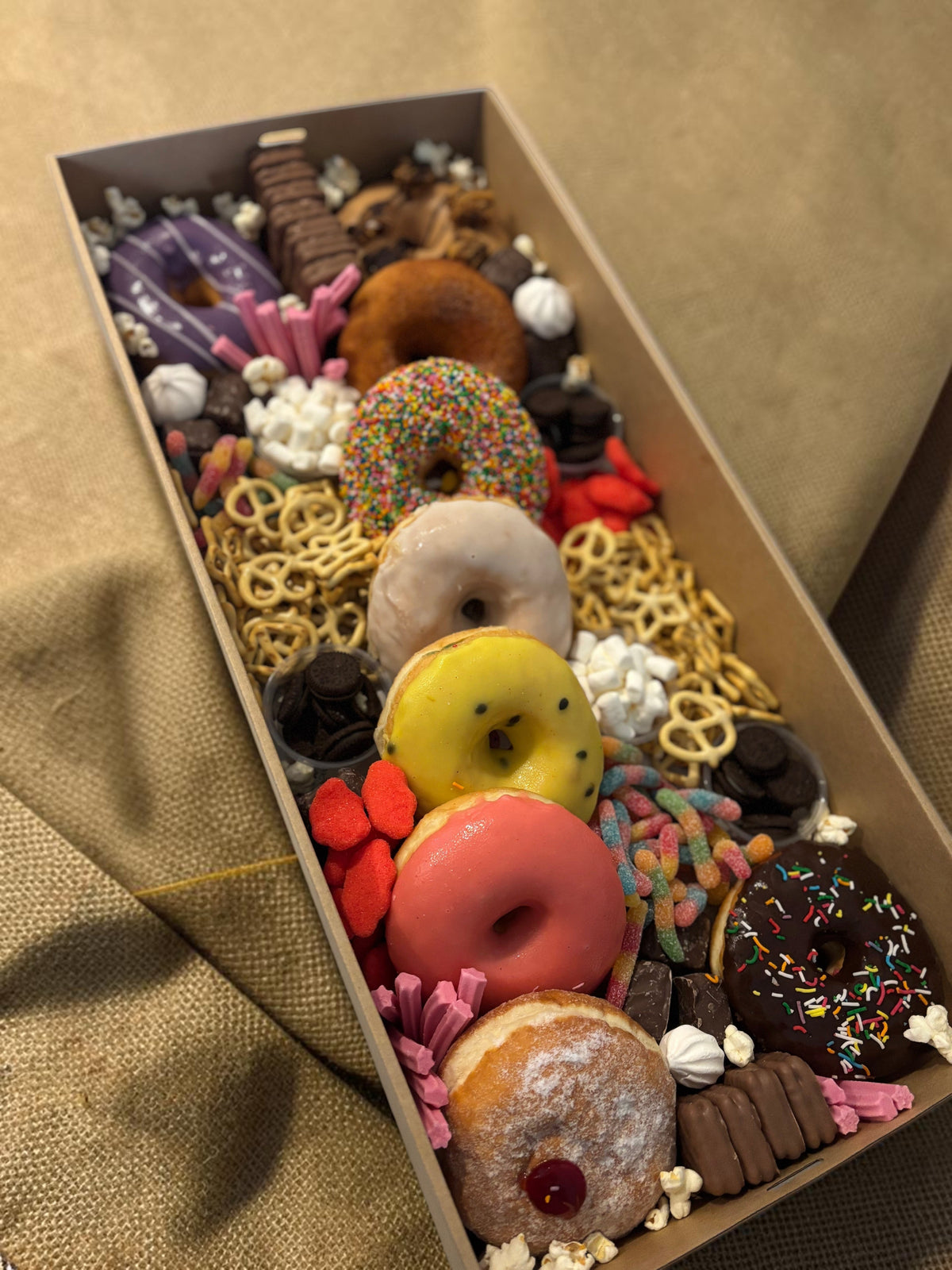 Donut Bouquet Canberra sweets grazing box filled with assorted donuts, pretzels, lollies, and chocolate treats.